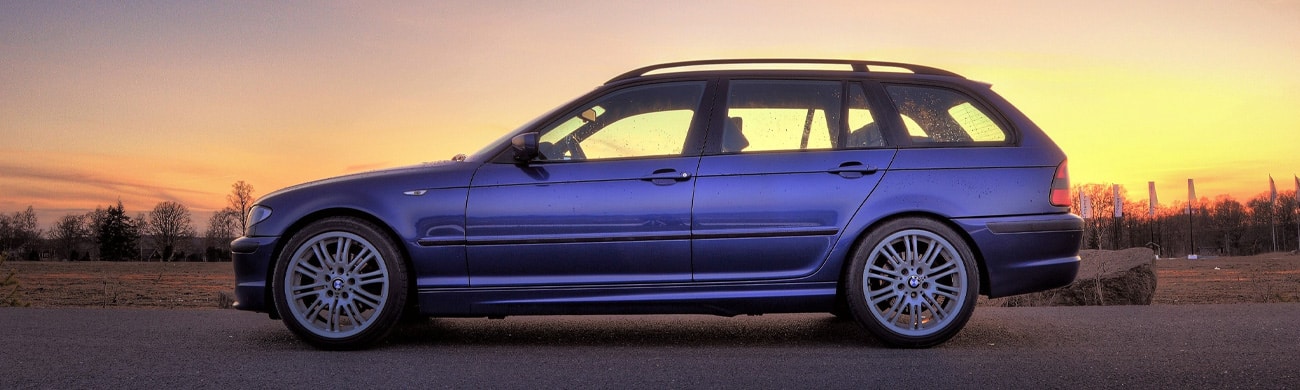 Blue SUV parked on road at sunset